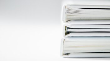 Expedientes técnicos archivados y apilados sobre un fondo claro