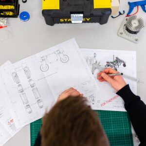 Planos técnicos marcándose a mano sobre una mesa